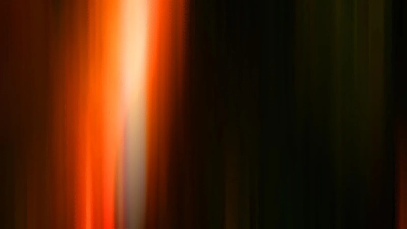 Vertikale, verwischte Lichtstreifen in Orange und Weiß auf dunklem Grund; links hell leuchtend, rechts fast schwarz.