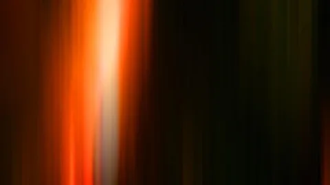 Vertikale, verwischte Lichtstreifen in Orange und Weiß auf dunklem Grund; links hell leuchtend, rechts fast schwarz.