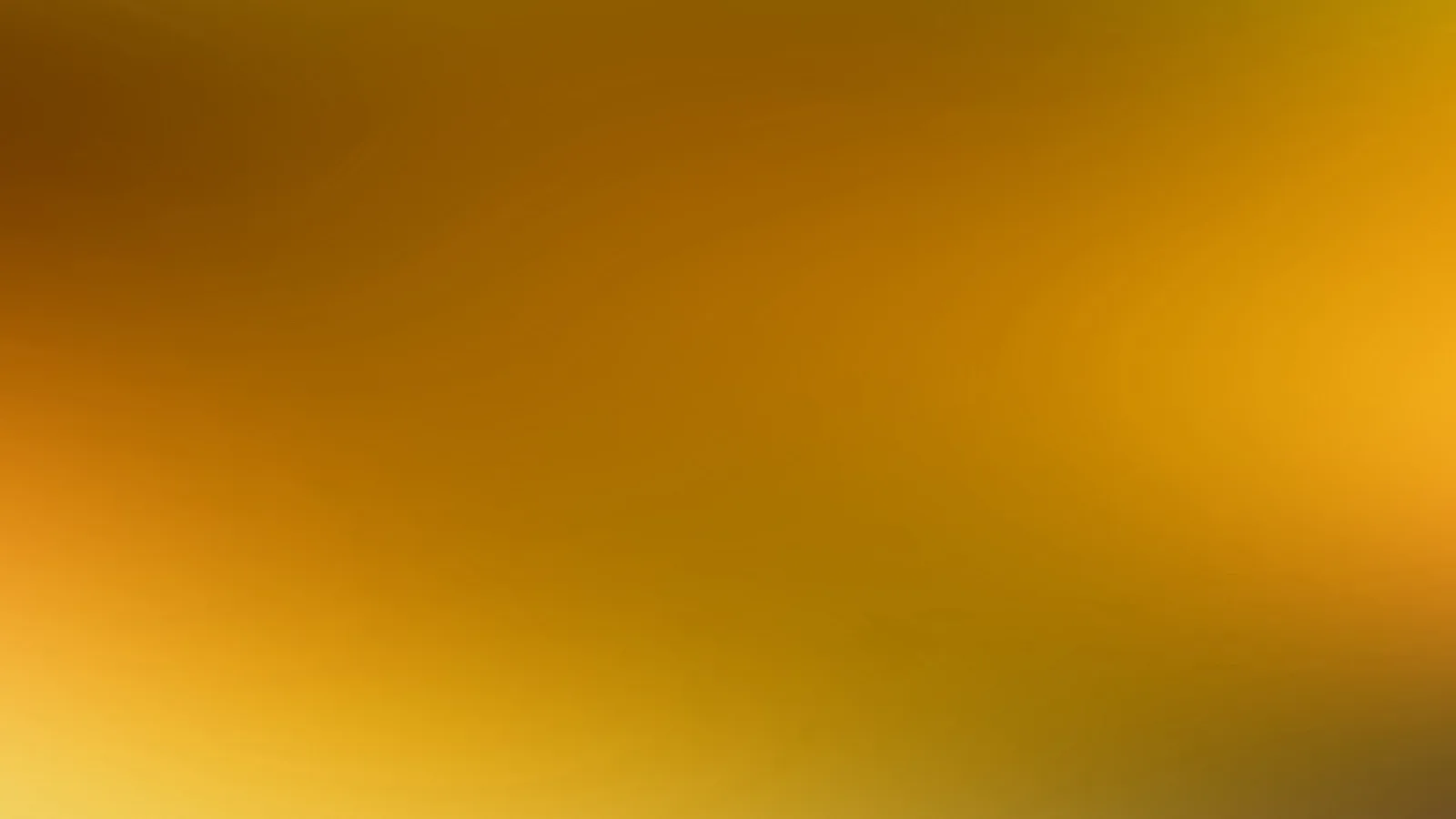 Unscharfer Farbverlauf von dunklem Braun oben links über Orange bis zu hellem Gelb unten links und Gold rechts.