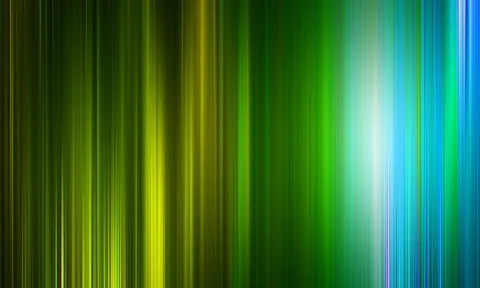 Vertikal verwischte Lichtstreifen in Grün, Gelb und Blau, nach rechts heller werdend mit einem weißen Leuchten in der Mitte rechts.