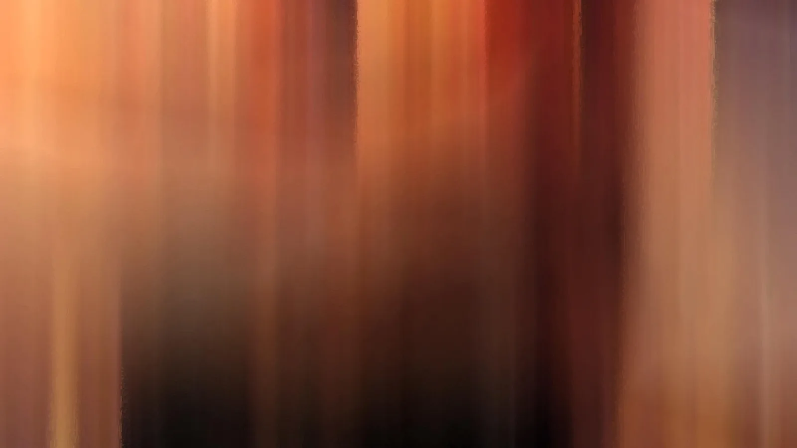 Abstrakte, senkrecht verwischte Streifen in Orange, Rot und Braun, die nach unten in Dunkelbraun übergehen.