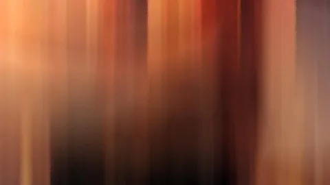 Abstrakte, senkrecht verwischte Streifen in Orange, Rot und Braun, die nach unten in Dunkelbraun übergehen.