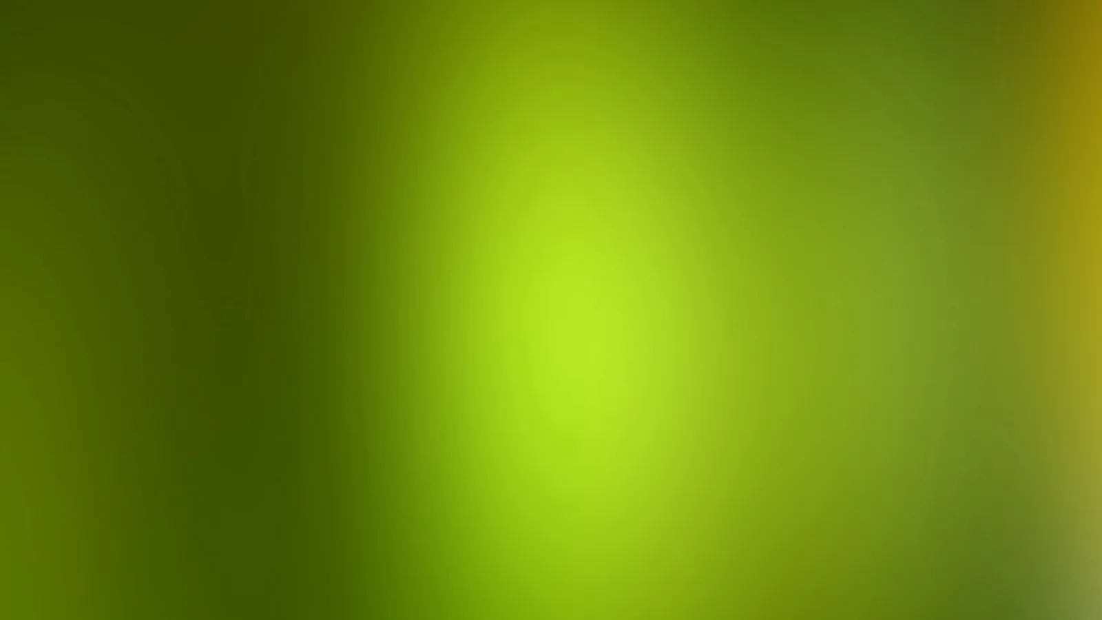 Unscharfer Farbverlauf in Grüntönen mit einem hellgelben Lichtfleck in der Mitte und einem gelblichen Schimmer am rechten Rand.