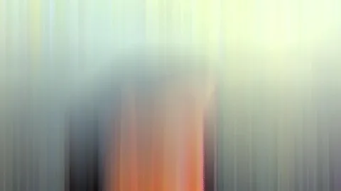 Abstrakte, vertikal verwischte Farbflächen in Grün, Gelb und Grau, unten mittig ein orangefarbener Streifen.