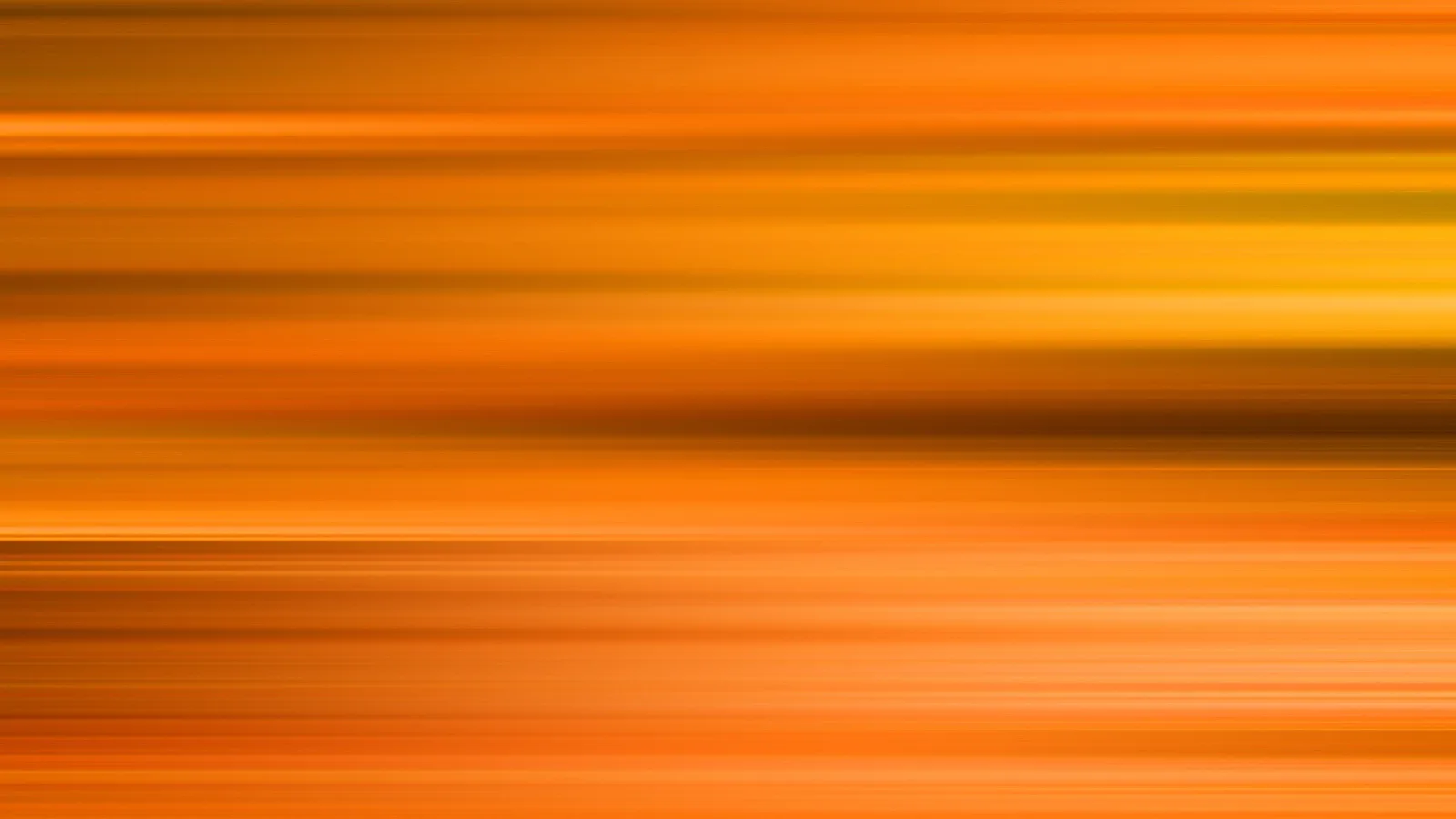 Abstrakte Fläche aus horizontalen, verschwommenen Streifen in Orange, Gelb und Braun