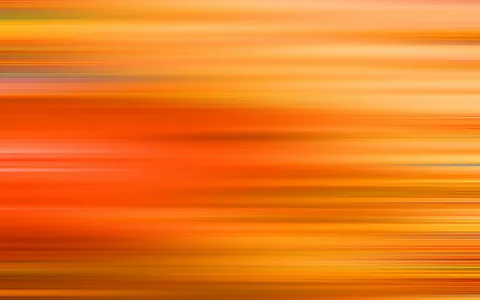 Abstrakte Komposition aus waagerechten, unscharfen Streifen in Orange, Gelb und Rot, die von links nach rechts verlaufen.