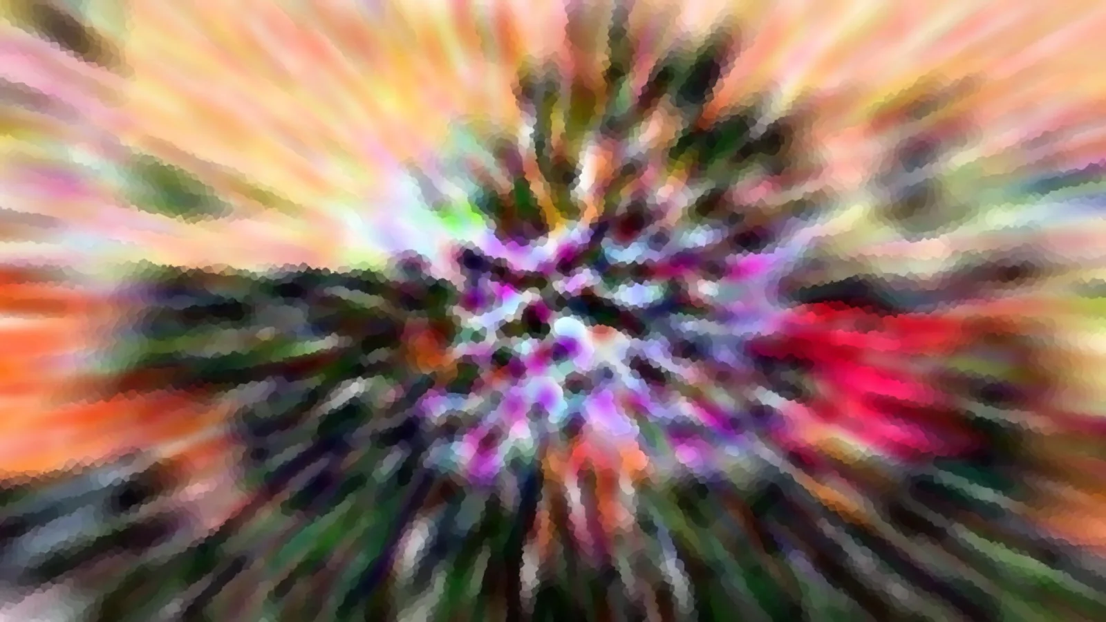 Abstrakte Aufnahme mit radialer Bewegungsunschärfe, im Zentrum pink, lila und grüne Farbtupfer, außen Orange und Gelb.