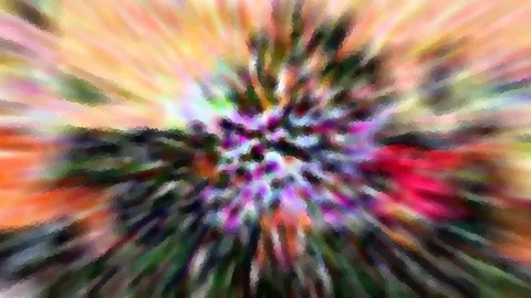 Abstrakte Aufnahme mit radialer Bewegungsunschärfe, im Zentrum pink, lila und grüne Farbtupfer, außen Orange und Gelb.