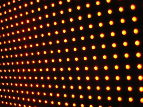 Raster aus gelb-orange leuchtenden Punkten auf schwarzem Hintergrund, die in perspektivischen Reihen angeordnet sind.