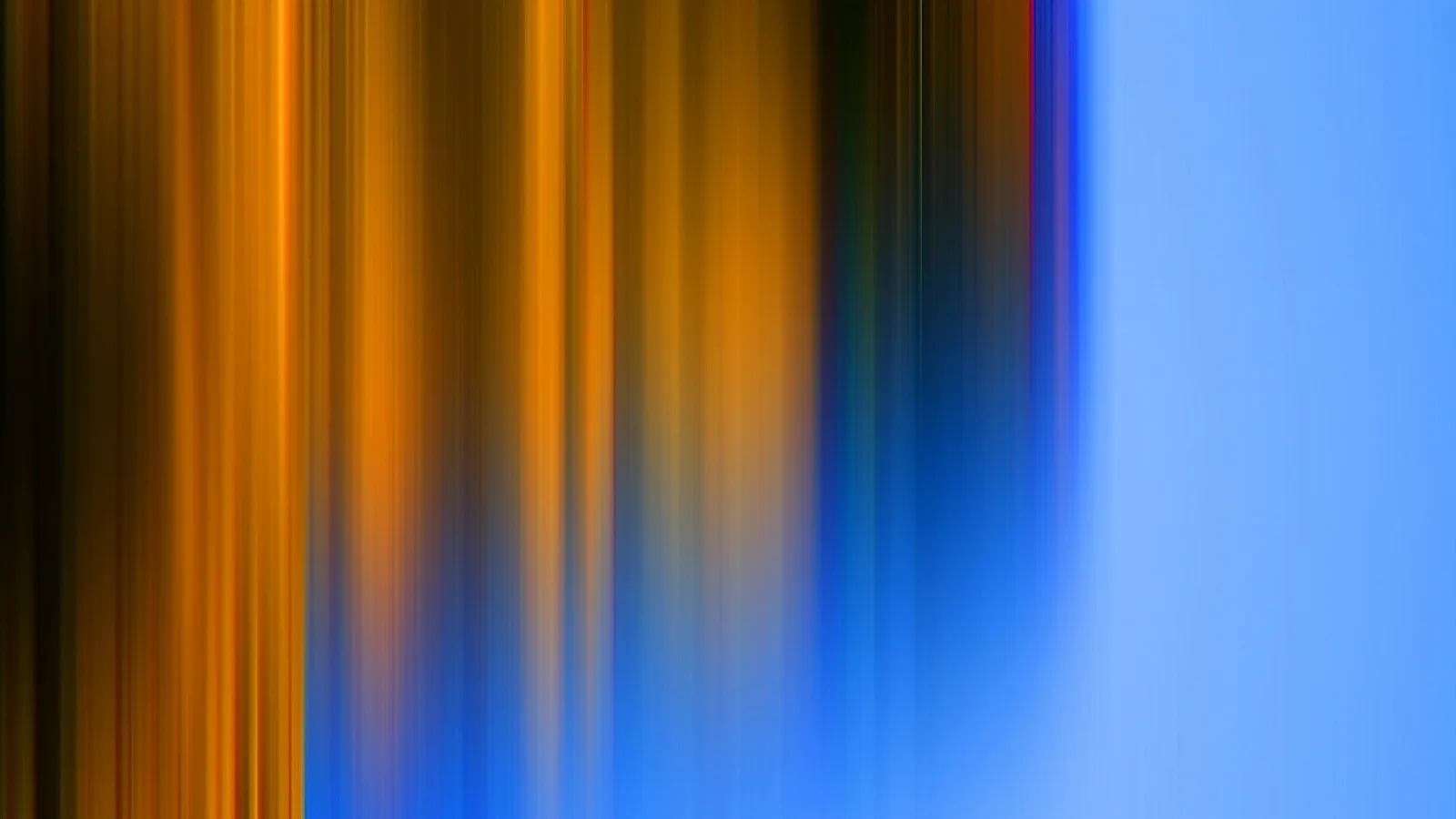 Abstrakte vertikale Schlieren in Orange, Gelb und Blau, links dunkel und warm, rechts eine helle, glatte blaue Fläche.