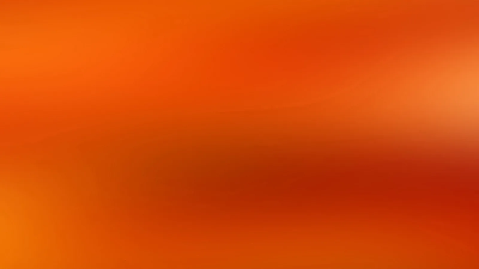 Unscharfer Verlauf in Orange und Rot mit helleren Lichtflecken am rechten Rand und dunkleren Rottönen in der Mitte.
