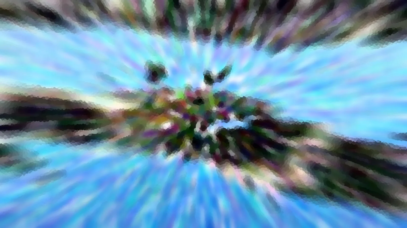 Radial verwischtes Bild mit blauen Strahlen, dunklen Streifen und einem bunten, verschwommenen Knäuel in der Mitte.