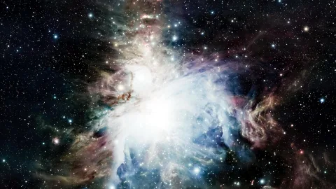 Leuchtende Gaswolke des Orionnebels, durchsetzt von hellen Sternen und dunklen Staubbahnen vor schwarzem Weltraum.