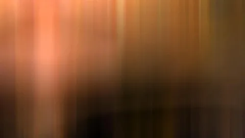 Unscharfe, vertikal verwischte Farbflächen von hellem Orange über Braun bis zu Schwarz am unteren Rand.