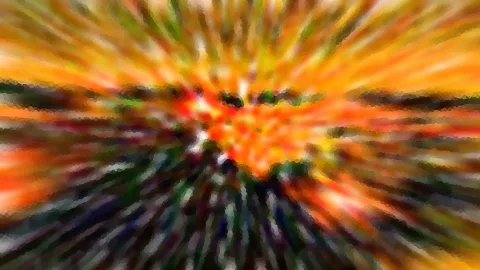 Abstrakte, radial verwischte Farbstrahlen in Orange, Gelb und Grün, die von einem hellen Zentrum nach außen laufen.