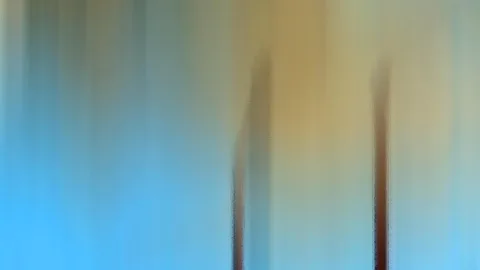 Abstrakte, vertikal verwischte Farbflächen: links und oben blau, in der Mitte warmes Gold, unten zwei dunkle, schmale Formen.