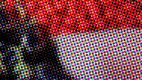 Abstraktes Muster aus farbigen Punkten in Rot, Schwarz, Grün, Blau und Weiß, oben dicht und rot, links unten fast schwarz.