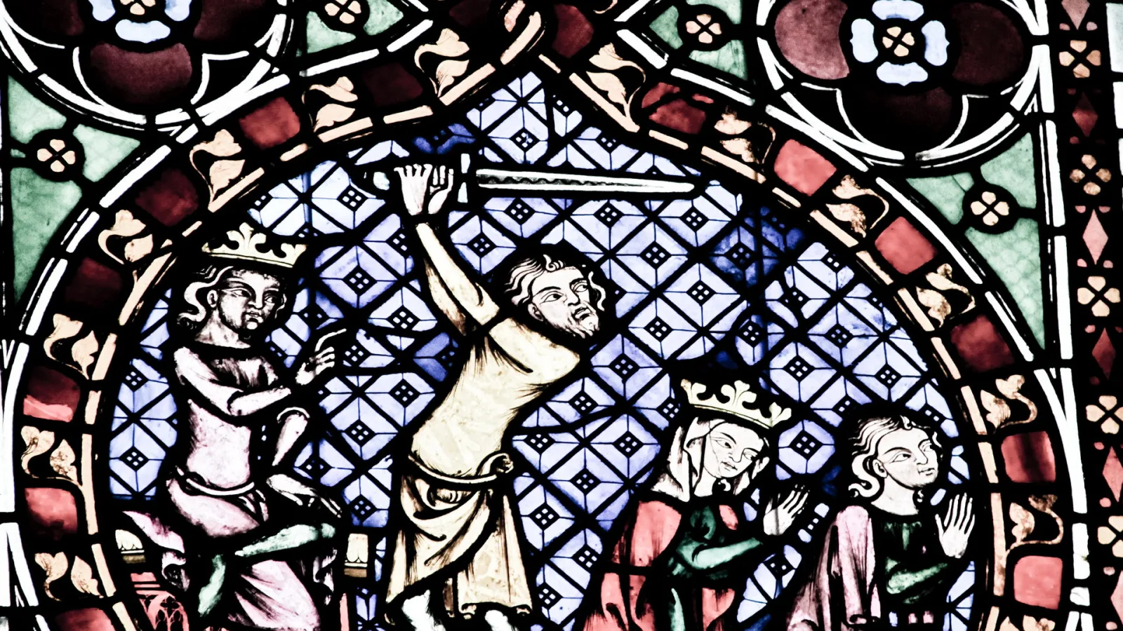 Mittelalterliches Glasfenster mit vier Figuren vor einem blau-weiß gemusterten Hintergrund. In der Mitte hebt ein Mann in hellem Gewand den Arm, links und rechts stehen gekrönte Gestalten, ganz rechts eine weitere Figur.