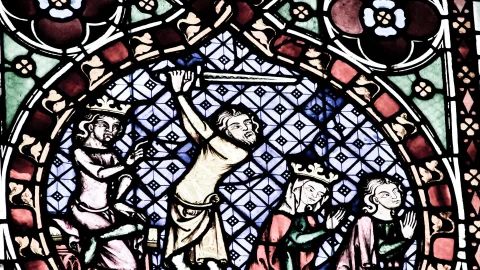 Mittelalterliches Glasfenster mit vier Figuren vor einem blau-weiß gemusterten Hintergrund. In der Mitte hebt ein Mann in hellem Gewand den Arm, links und rechts stehen gekrönte Gestalten, ganz rechts eine weitere Figur.