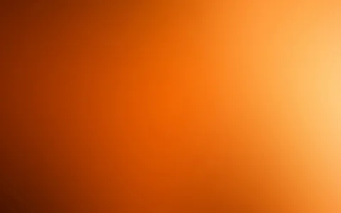 Weich verschwommener Verlauf in Orange und Braun, rechts oben ein heller gelblicher Lichtschein, nach links unten dunkler werdend.
