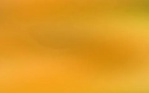 Weich verlaufende Fläche in Orange- und Gelbtönen mit dunkleren, verschwommenen Bereichen in der Mitte und unten.