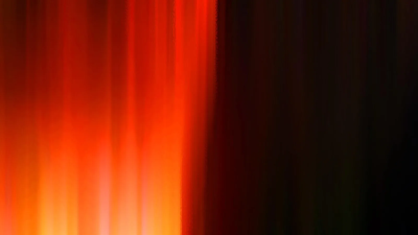 Vertikale orangerote Lichtstreifen, die von links unten nach oben hell leuchten und nach rechts in dunkles Schwarzrot übergehen.
