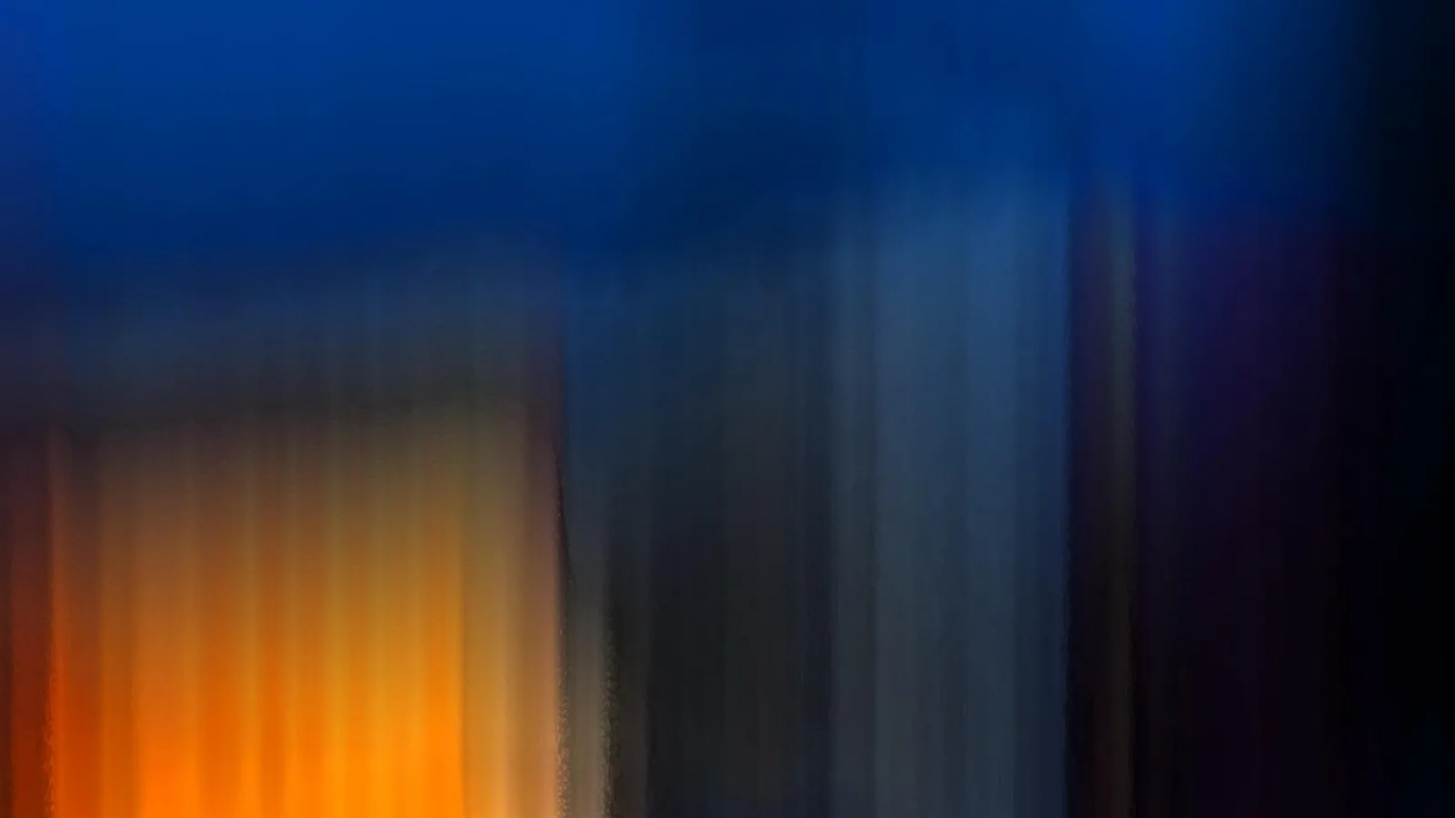 Abstrakte Bewegungsunschärfe mit vertikalen Streifen in Blau, Orange und Dunkelgrau, links ein warmer oranger Bereich.