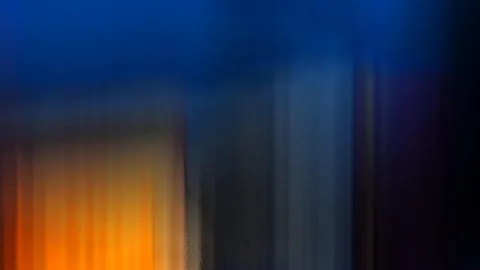 Abstrakte Bewegungsunschärfe mit vertikalen Streifen in Blau, Orange und Dunkelgrau, links ein warmer oranger Bereich.