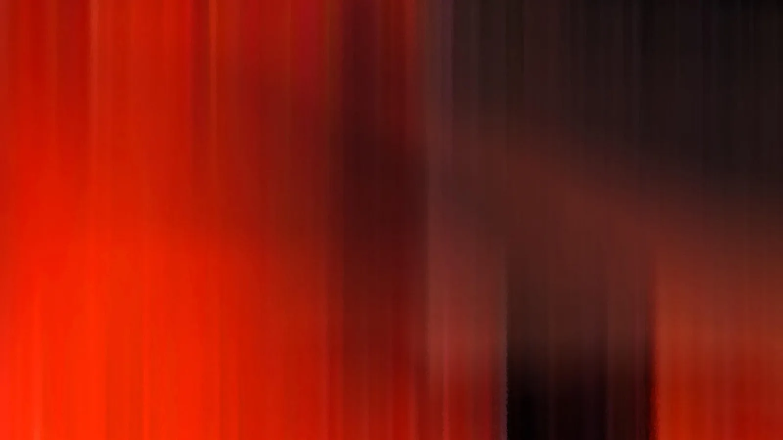 Vertikal verwischte rote Streifen auf der linken Seite, die in eine fast schwarze Fläche auf der rechten Seite übergehen.
