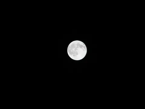 Ein heller Vollmond vor schwarzem Nachthimmel, mit sichtbaren Kratern auf der Oberfläche.