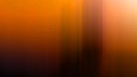 Abstrakte, verwischte vertikale Streifen in Orange, Braun und Dunkelviolett, oben rechts ein heller Lichtschein.