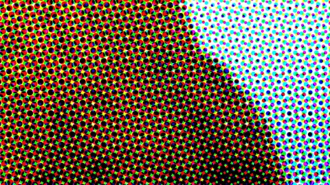 Dichtes Raster aus bunten Punkten in Rot, Grün, Gelb, Blau, Cyan und Magenta auf Schwarz und Weiß, das von links nach rechts in helle Fläche übergeht.