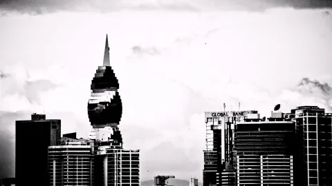 Schwarzweiß-Aufnahme einer Stadtsilhouette mit einem spitz zulaufenden Hochhaus in der Mitte, rechts ein Gebäude mit der Aufschrift Global Bank, davor heller bewölkter Himmel.