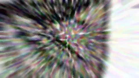 Abstraktes Bild mit radialer Unschärfe: bunte Streifen in Grün, Lila und Weiß laufen von der Mitte nach außen.