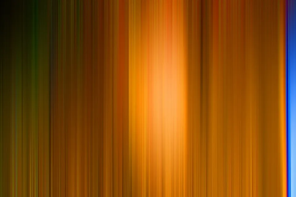 Abstrakte vertikale Streifen in Orange, Gold und Dunkelbraun, in der Mitte leuchtend hell, am rechten Rand ein blauer Streifen.
