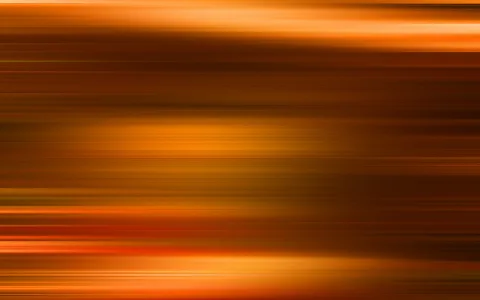 Waagerecht verwischte Streifen in Orange, Braun und Gelb auf dunklem Grund.
