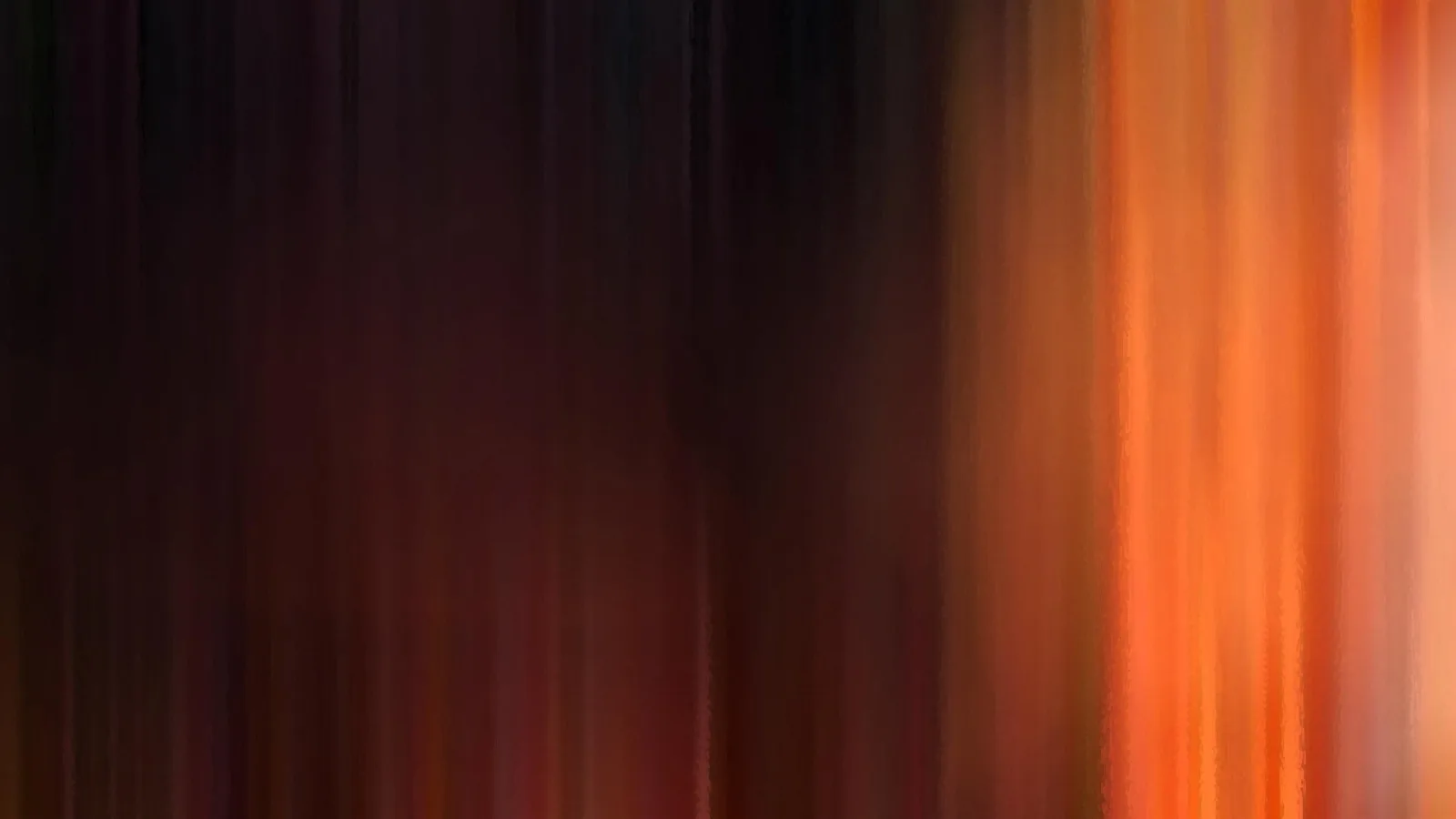 Vertikal verwischte Streifen in Orange und Rot auf dunklem Grund, rechts deutlich heller.