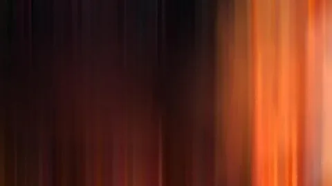 Vertikal verwischte Streifen in Orange und Rot auf dunklem Grund, rechts deutlich heller.