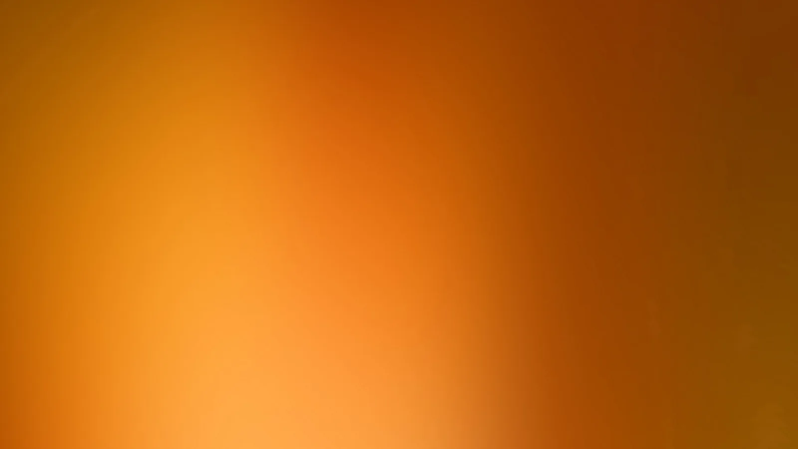 Weicher Farbverlauf von Orange über Rotorange bis Braun, heller unten links und dunkler oben rechts.