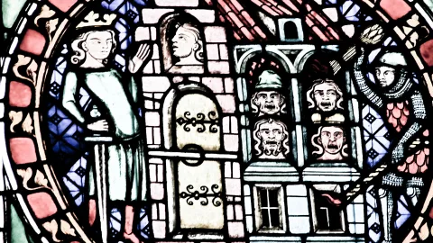 Mittelalterliches Glasfenster: links ein gekrönter Herrscher mit erhobener Hand, in der Mitte ein Turmhaus mit Bogentür und Köpfen in den Fenstern, rechts ein Ritter mit Helm und Kettenhemd.