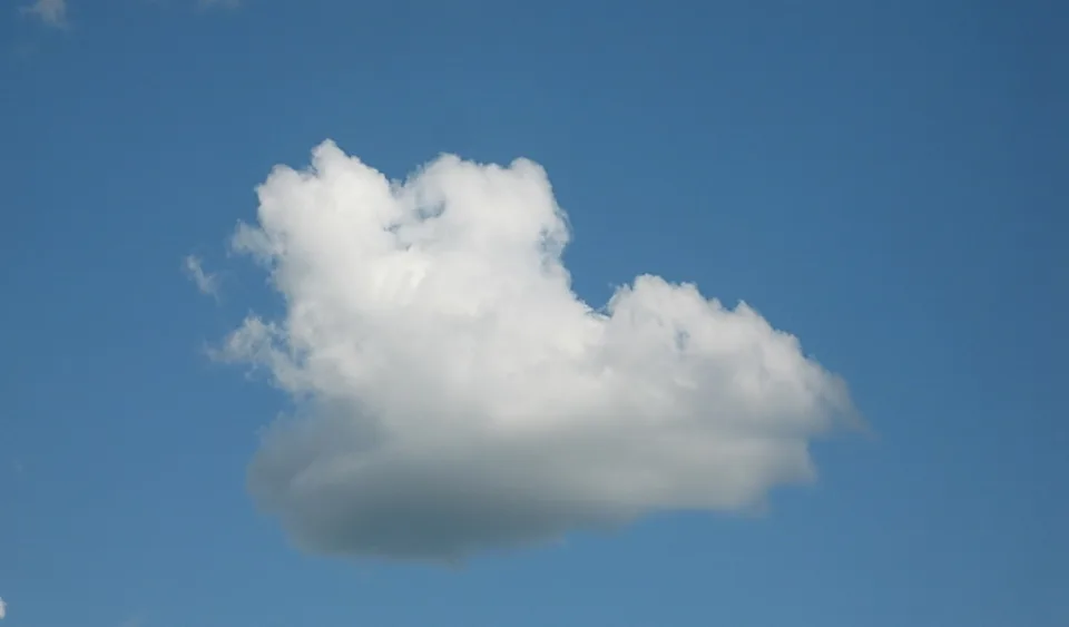 Eine weiße Quellwolke vor klarem blauem Himmel, leicht links der Bildmitte.