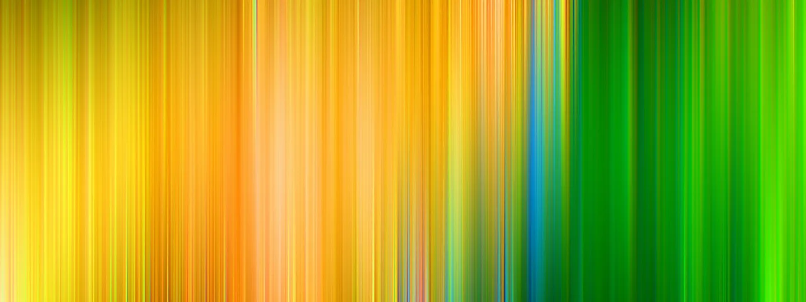 Abstraktes Bild aus senkrechten, unscharfen Streifen in Gelb, Orange, Grün und einem schmalen Blau