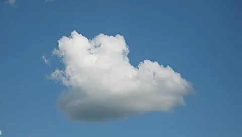 Eine weiße Haufenwolke vor klarem, hellblauem Himmel, im Zentrum leicht nach rechts versetzt.