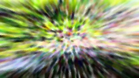 Abstrakte Komposition aus grünen, gelben und violetten Farbstrahlen, die von einem hellen Zentrum radial nach außen verlaufen