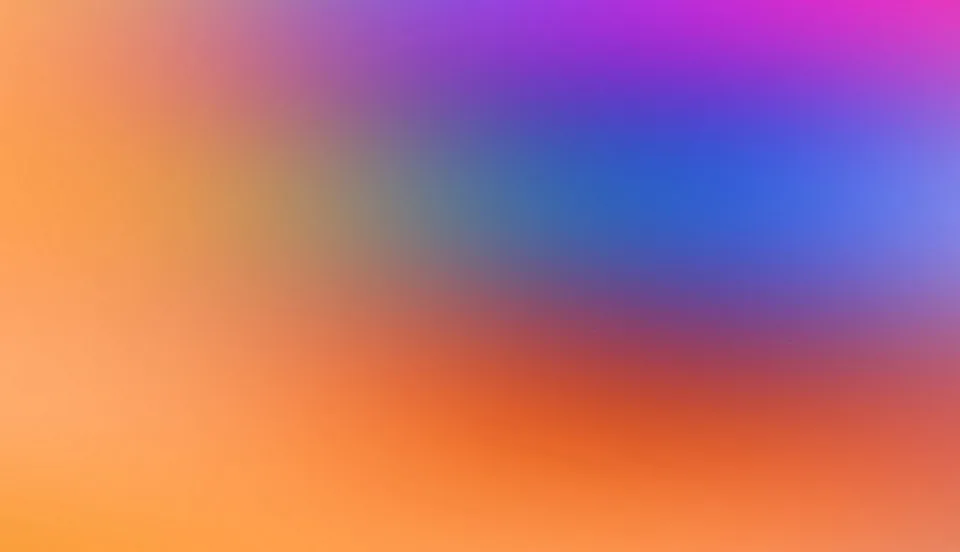 Abstrakter, unscharfer Farbverlauf von Orange links und unten über Blau und Violett bis Magenta oben rechts.