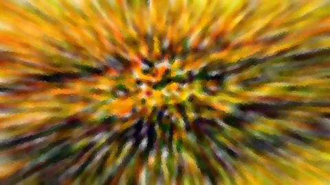 Abstrakte radiale Unschärfe mit orangen, gelben und grünen Streifen, die aus einem dunkleren Zentrum nach außen strahlen.