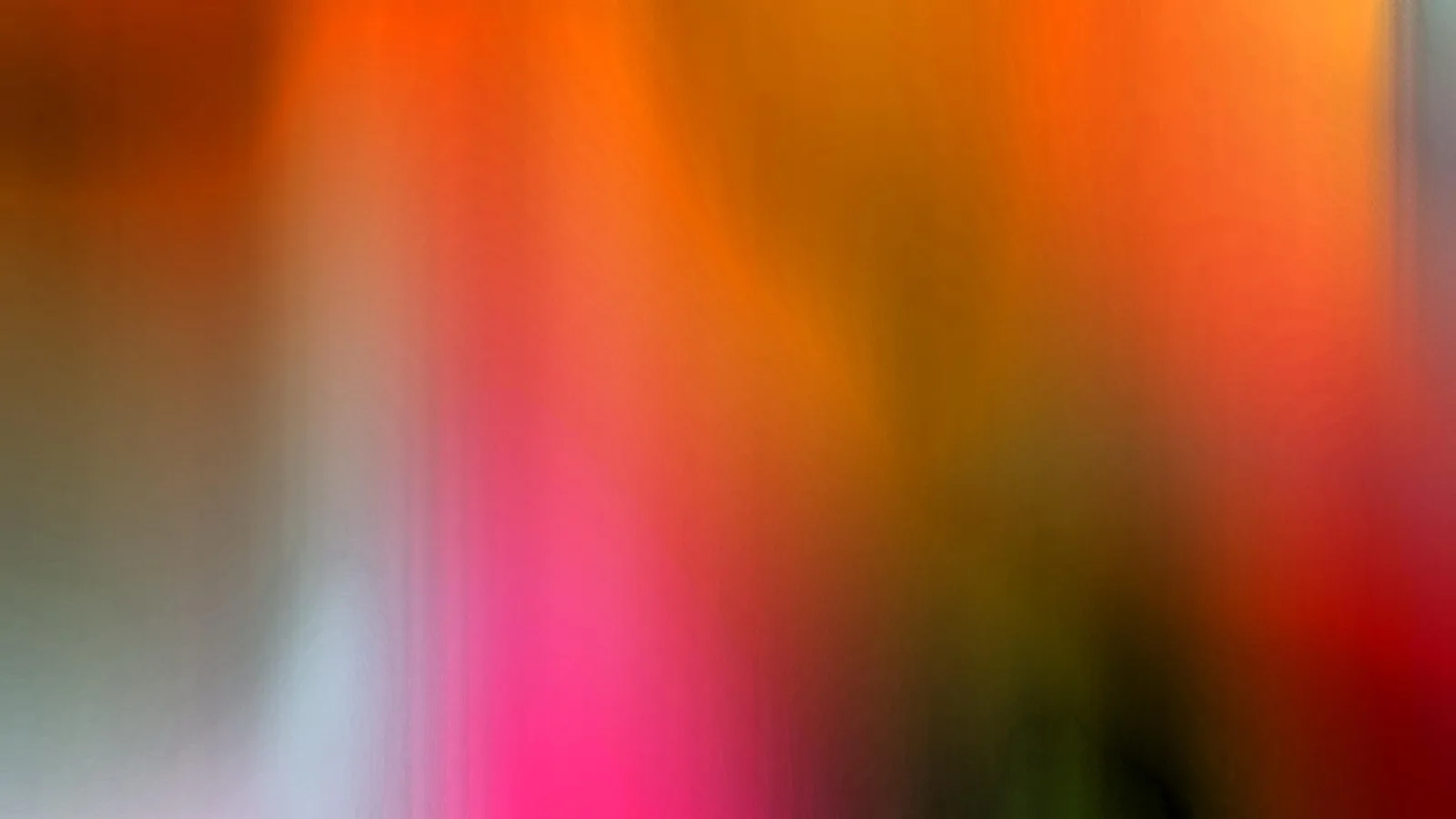 Abstrakte, vertikal verwischte Farbflächen in Orange, Pink, Rot und Grün