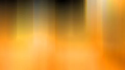 Abstrakte, verwischte vertikale Streifen in Orange, Gelb und Schwarz, oben dunkler, unten hell leuchtend.