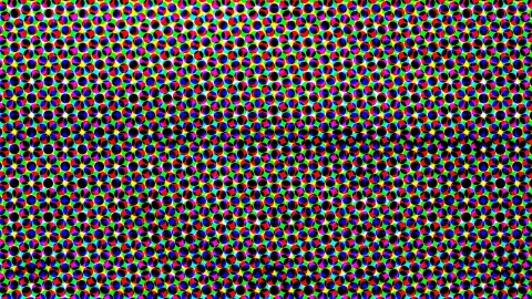 Dichtes, regelmäßiges Muster aus kleinen farbigen Kreisen in Rot, Grün, Blau, Gelb, Magenta und Schwarz auf hellem Raster.