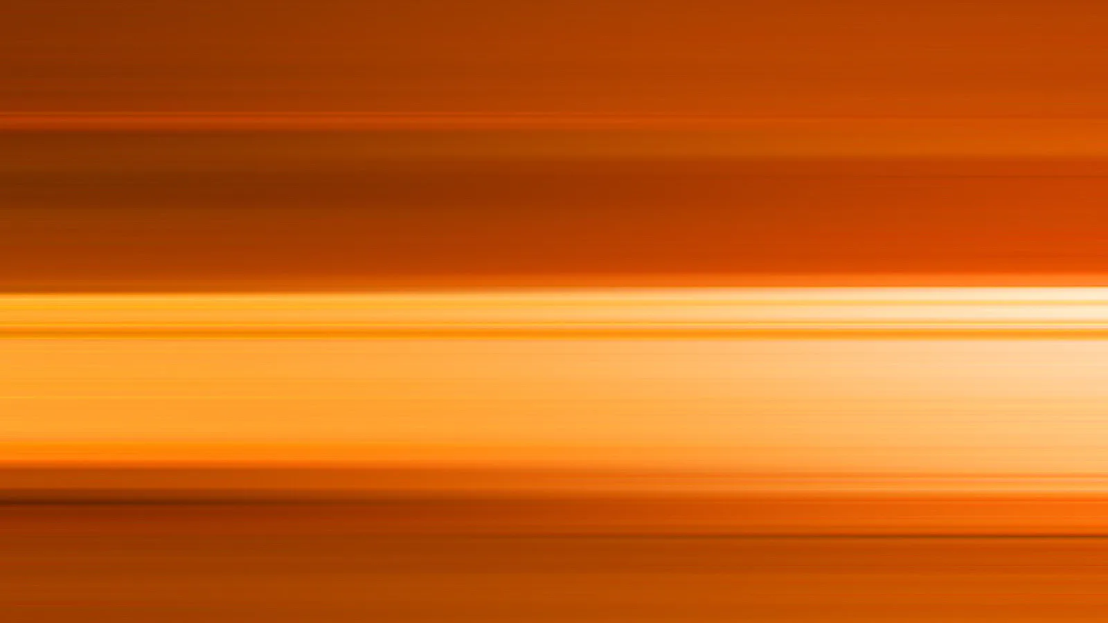 Horizontal verwischte Streifen in Orange- und Gelbtönen, im Zentrum ein helles, cremefarbenes Band.